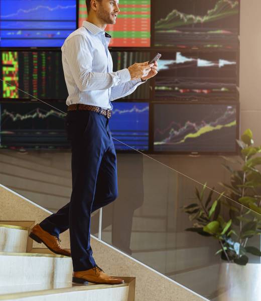 successful smart caucasian businessman walking on stair trade stock with smartphone communicate with happiness and enthusiastic modern office background